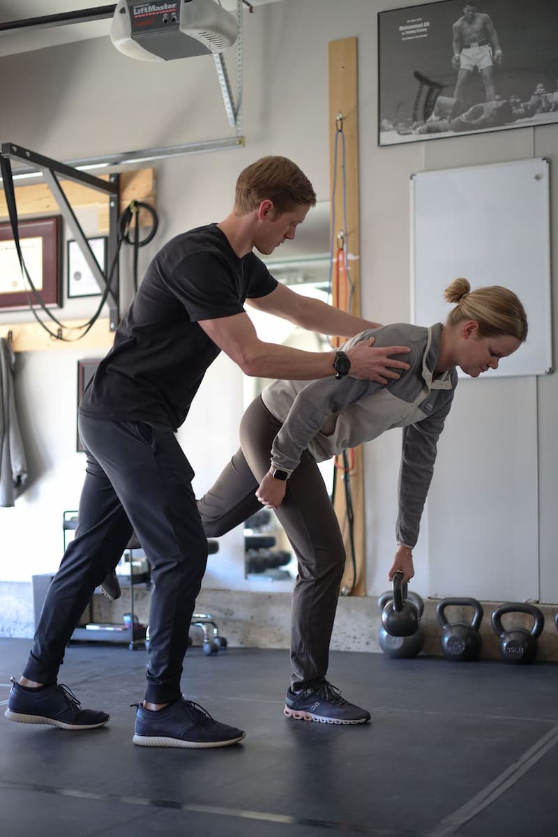 Dr. Wade helps a patient achieve proper form with a kettlebell exercise